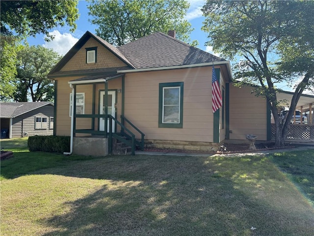 112 N Burns St N, Independence, KS 67301 - bungalow-style home with a front lawn, a chimney, and roof with shingles