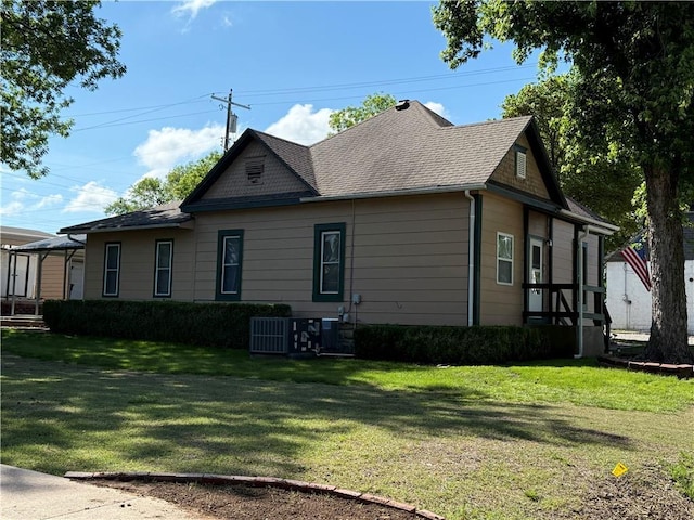 112 N Burns St N, Independence, KS 67301 - view of property exterior featuring a lawn, cooling unit, and roof with shingles