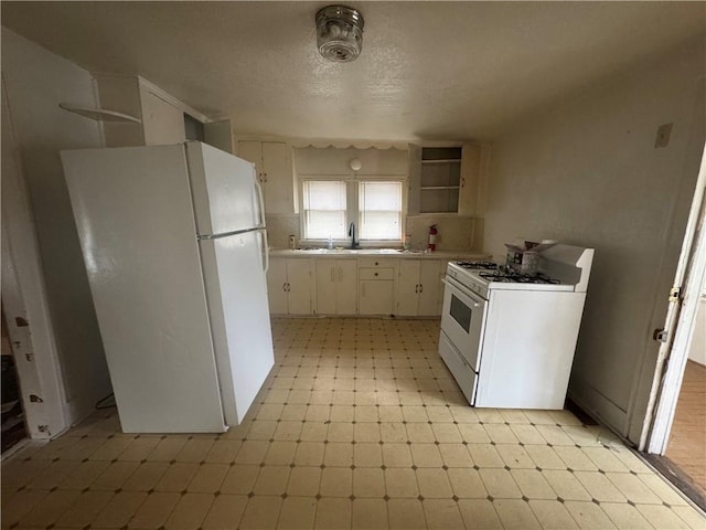231 Osage St, Leavenworth, KS 66048 - kitchen featuring white appliances, open shelves, light floors, light countertops, and white cabinetry