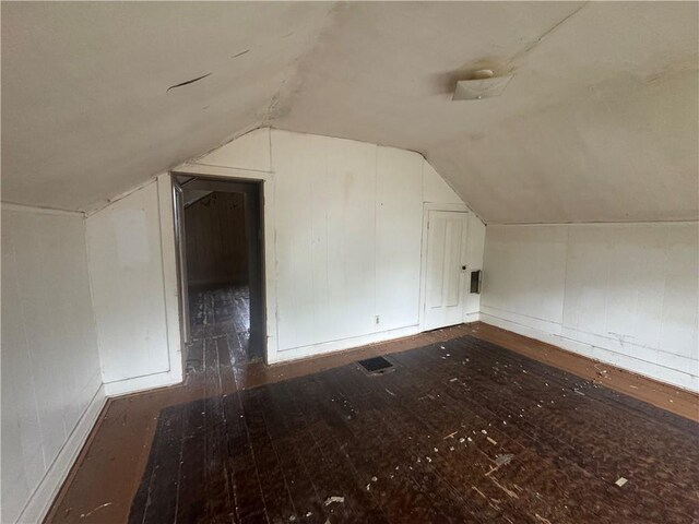 231 Osage St, Leavenworth, KS 66048 - additional living space featuring hardwood / wood-style flooring, vaulted ceiling, baseboards, and a decorative wall