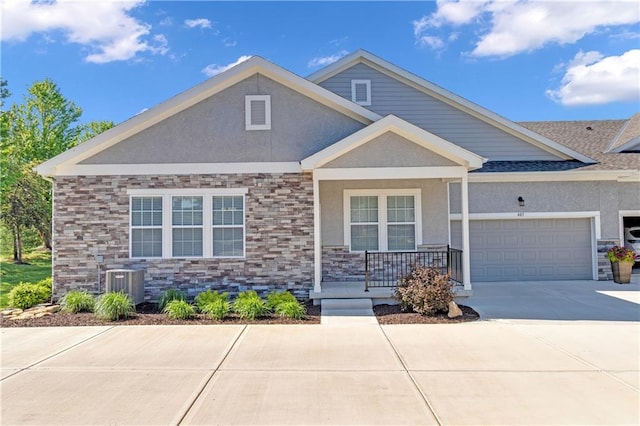 11961 S Tallgrass Dr Unit 403, Olathe, KS 66061 - view of front of house featuring a porch, stucco siding, driveway, an attached garage, and stone siding