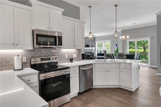 11961 S Tallgrass Dr Unit 403, Olathe, KS 66061 - kitchen featuring stainless steel appliances, a peninsula, ornamental molding, tasteful backsplash, and light countertops