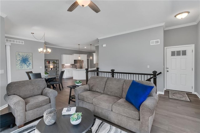 11961 S Tallgrass Dr Unit 403, Olathe, KS 66061 - living area with a chandelier, ornamental molding, ceiling fan, wood finished floors, and baseboards