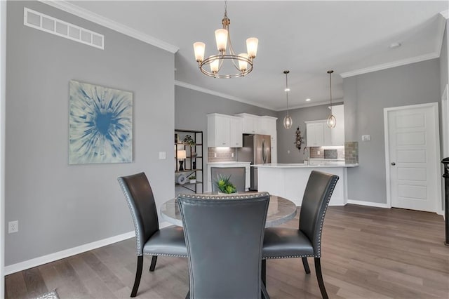 11961 S Tallgrass Dr Unit 403, Olathe, KS 66061 - dining space featuring a chandelier, wood finished floors, baseboards, crown molding, and recessed lighting