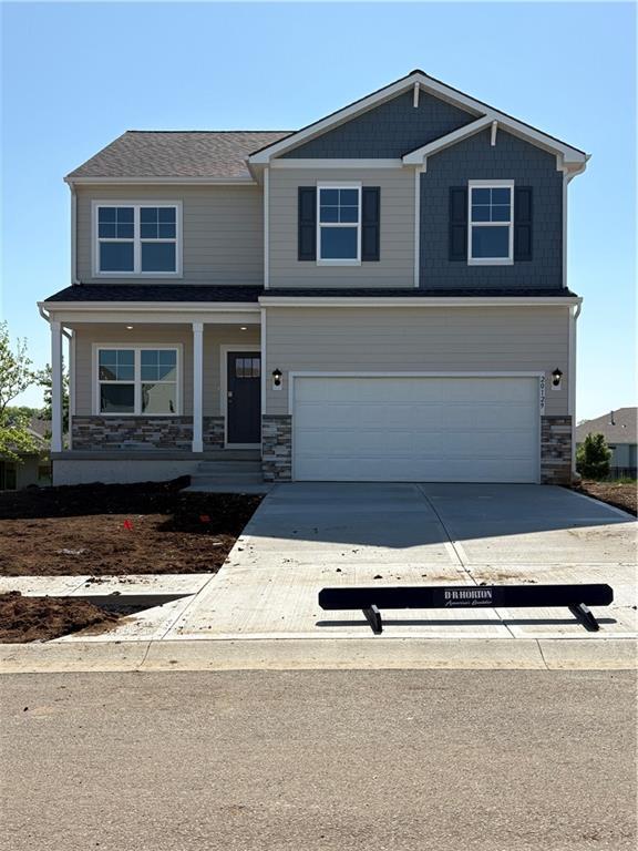 craftsman-style home featuring a garage, stone siding, and concrete driveway