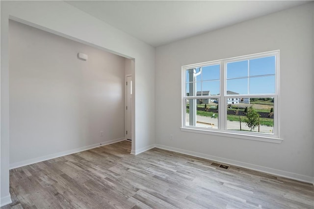 empty room with light wood-type flooring and baseboards