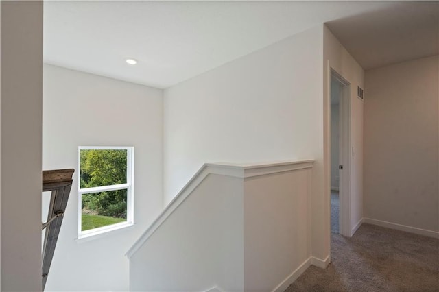 hallway featuring an upstairs landing, carpet flooring, baseboards, and recessed lighting