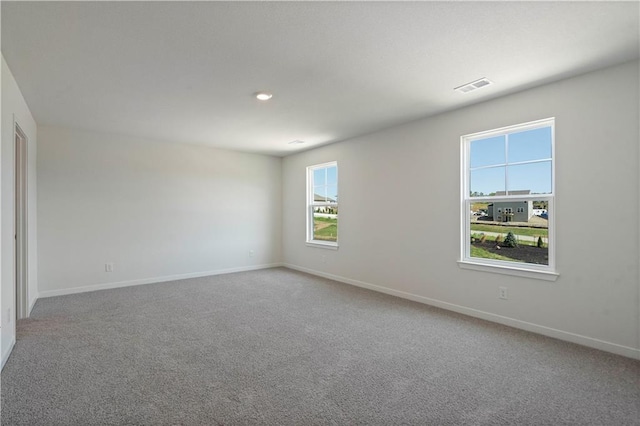 spare room featuring carpet floors and baseboards
