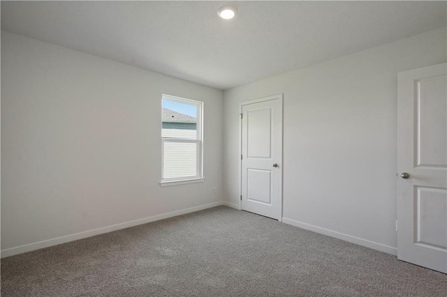 empty room with baseboards and carpet