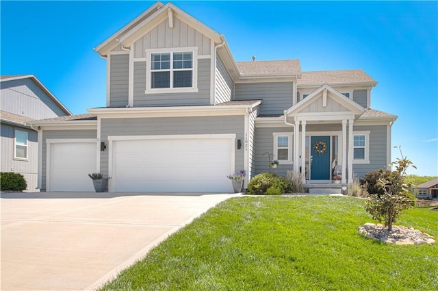 11021 N Oxford Ave, Kansas City, MO 64157 - view of front of property with a front yard, board and batten siding, driveway, and a garage