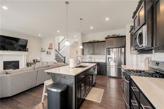 11021 N Oxford Ave, Kansas City, MO 64157 - kitchen with stainless steel appliances, a sink, decorative backsplash, open floor plan, and dark wood-style flooring