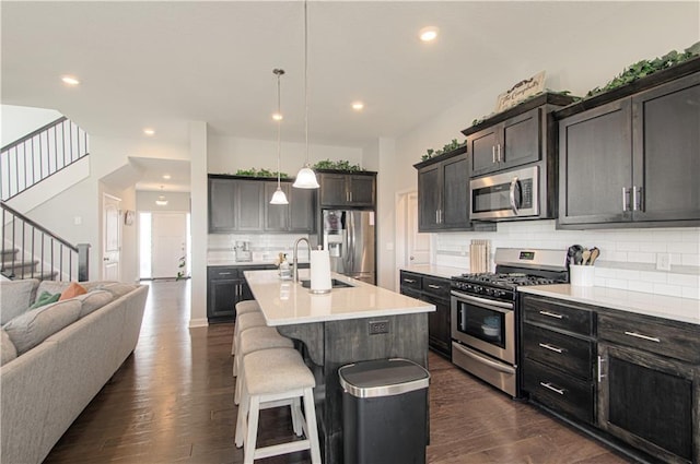 11021 N Oxford Ave, Kansas City, MO 64157 - kitchen featuring stainless steel appliances, a sink, open floor plan, backsplash, and light countertops