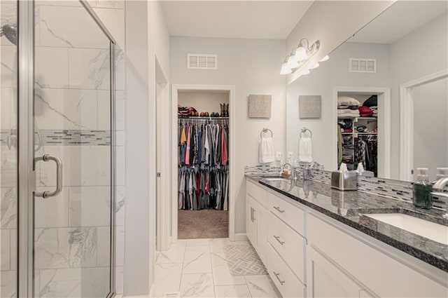 11021 N Oxford Ave, Kansas City, MO 64157 - bathroom featuring marble look tiles, a shower stall, double vanity, and a walk in closet