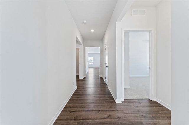 hall with dark wood-style flooring, baseboards, and recessed lighting