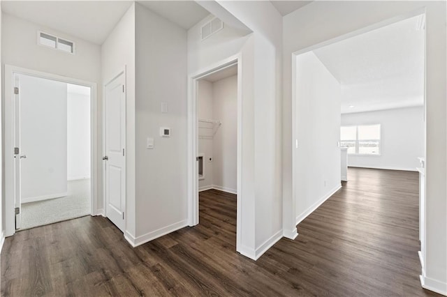 hall with dark wood finished floors and baseboards