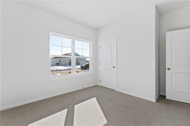 carpeted empty room with baseboards