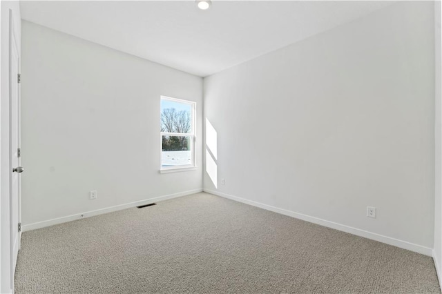 carpeted empty room featuring baseboards
