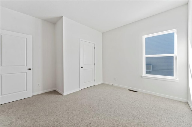 unfurnished room with carpet and baseboards