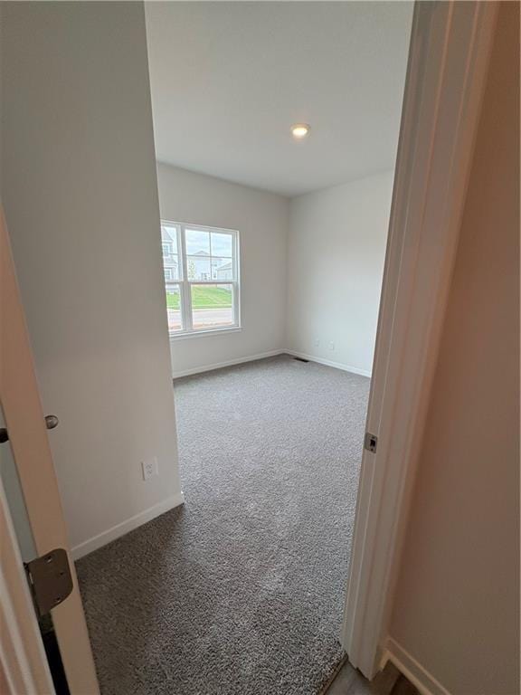 carpeted empty room with baseboards and recessed lighting
