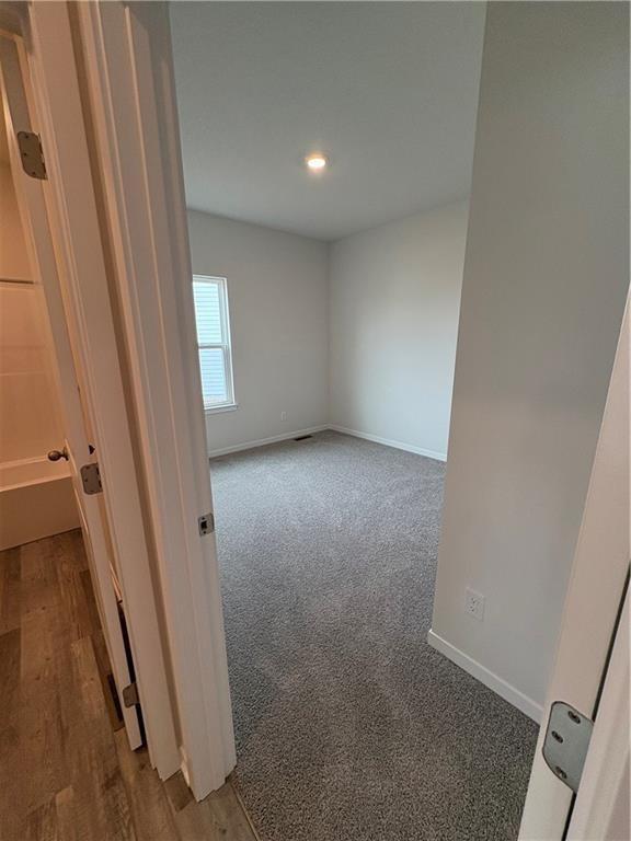 carpeted empty room featuring baseboards and recessed lighting