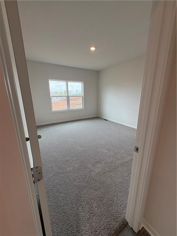 carpeted spare room featuring baseboards and recessed lighting