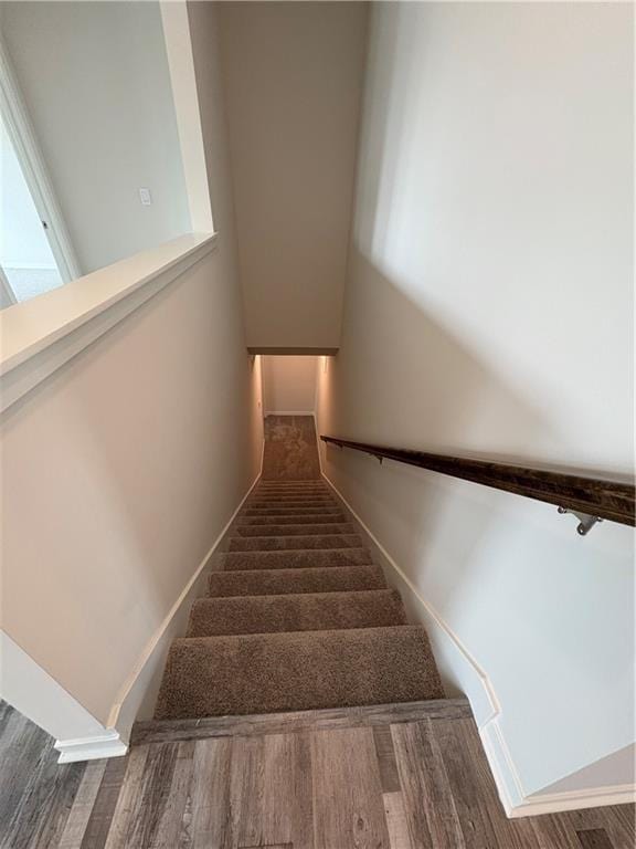 stairs with wood finished floors and baseboards