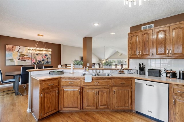 7703 NE 74th Ter, Kansas City, MO 64158 - kitchen with dishwasher, brown cabinets, a peninsula, light wood-style floors, and lofted ceiling