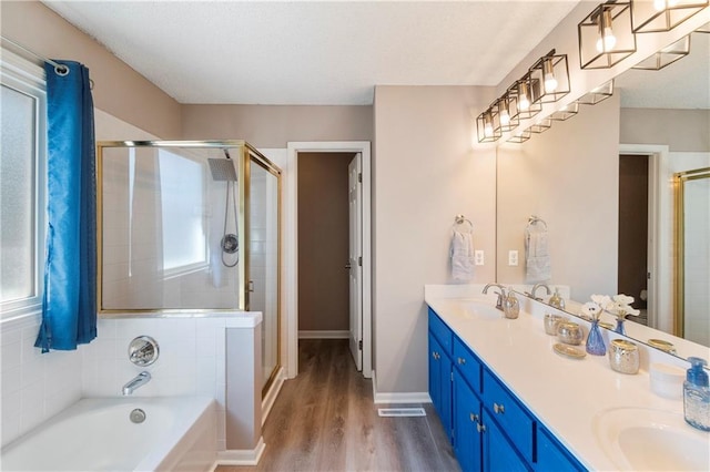7703 NE 74th Ter, Kansas City, MO 64158 - full bathroom featuring a shower stall, double vanity, a garden tub, and wood finished floors