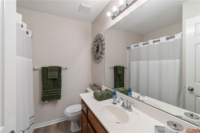 7703 NE 74th Ter, Kansas City, MO 64158 - full bathroom featuring vanity, wood finished floors, a textured ceiling, and a shower with curtain