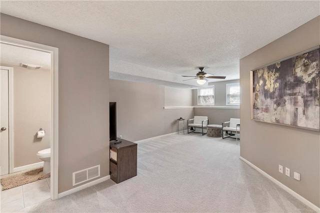 7703 NE 74th Ter, Kansas City, MO 64158 - living area featuring a textured ceiling, ceiling fan, and carpet floors