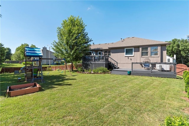 7703 NE 74th Ter, Kansas City, MO 64158 - rear view of property featuring a playground, a fenced backyard, and a wooden deck