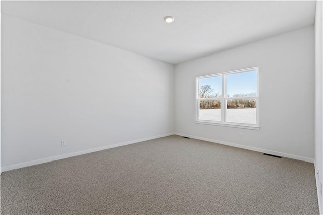 spare room featuring carpet flooring and baseboards