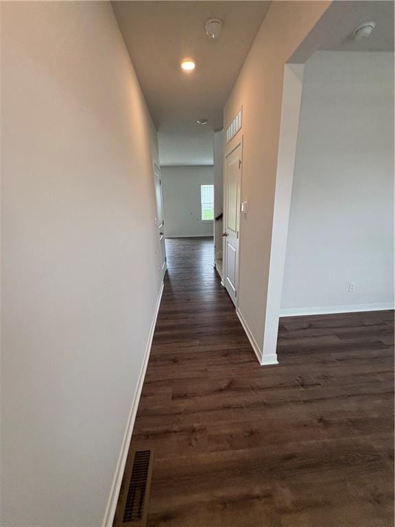 hallway featuring baseboards, dark wood-type flooring, and recessed lighting