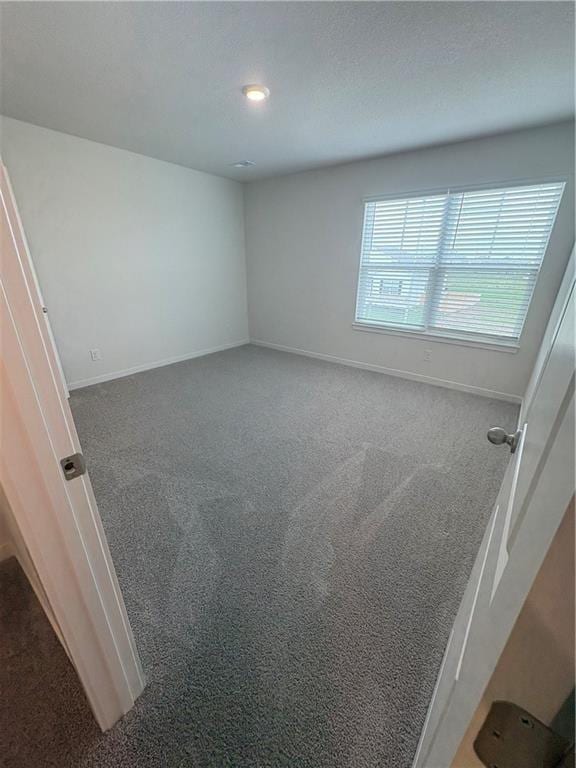 unfurnished room featuring carpet flooring and baseboards