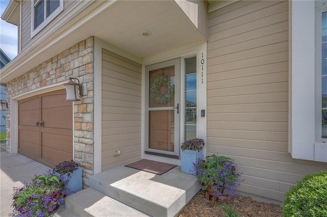 10111 N Tullis Dr, Kansas City, MO 64157 - entrance to property featuring stone siding and an attached garage