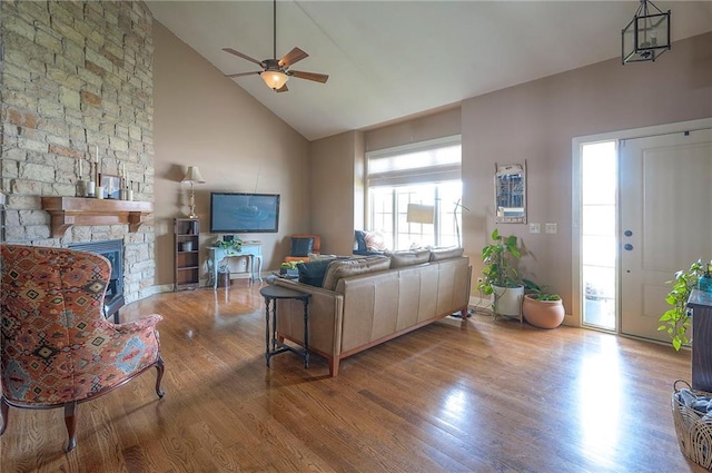 10111 N Tullis Dr, Kansas City, MO 64157 - living area with wood finished floors, a ceiling fan, high vaulted ceiling, and a stone fireplace