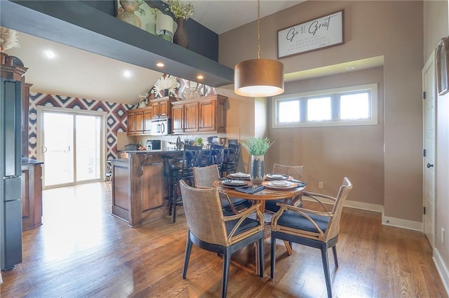 10111 N Tullis Dr, Kansas City, MO 64157 - dining space featuring wood finished floors, baseboards, and high vaulted ceiling