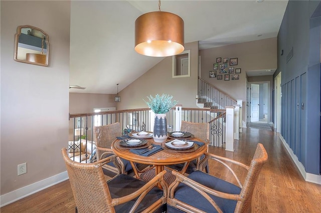 10111 N Tullis Dr, Kansas City, MO 64157 - dining area with wood finished floors, a towering ceiling, baseboards, and stairway