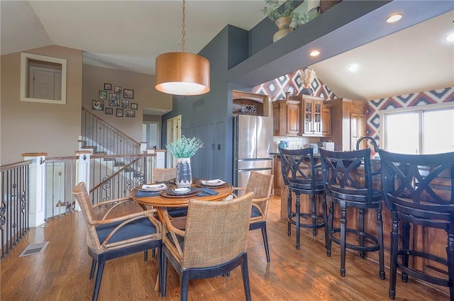 10111 N Tullis Dr, Kansas City, MO 64157 - dining area featuring vaulted ceiling, wood finished floors, and stairway