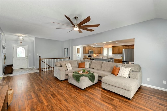living room featuring ceiling fan, dark wood-style flooring, baseboards, and plenty of natural light
