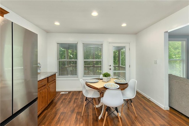 dining room featuring dark wood finished floors, plenty of natural light, baseboards, and recessed lighting