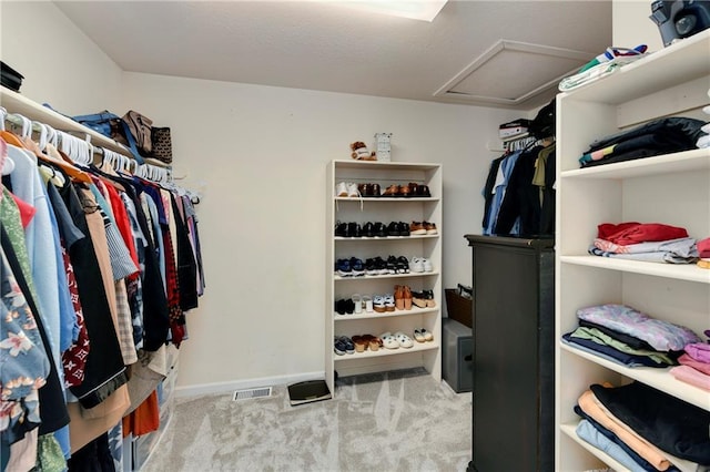 spacious closet featuring attic access and carpet