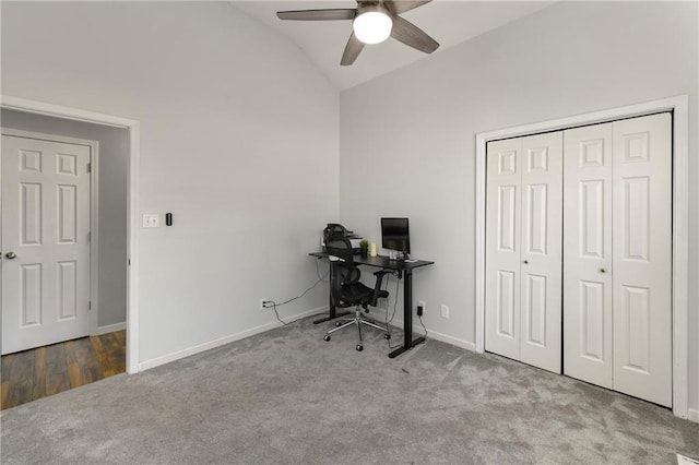 carpeted office space with vaulted ceiling, ceiling fan, and baseboards