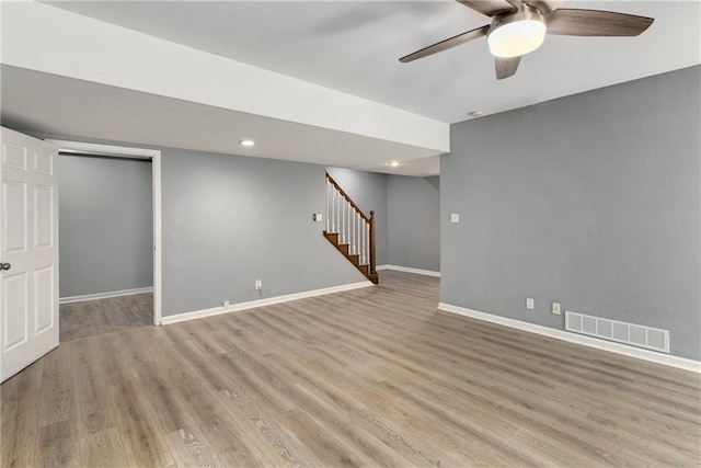 finished basement featuring stairs, wood finished floors, baseboards, a ceiling fan, and recessed lighting
