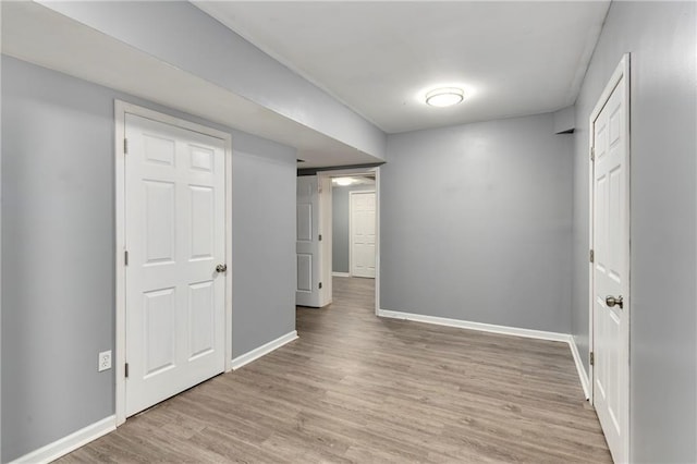 below grade area featuring light wood-style floors and baseboards
