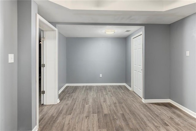 unfurnished room with wood finished floors and baseboards
