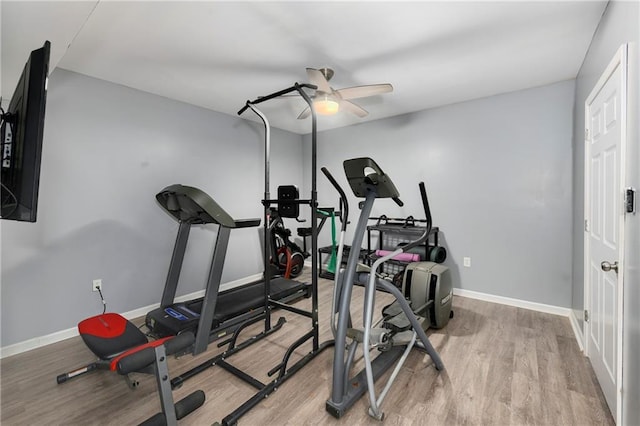 exercise area featuring a ceiling fan, light wood-style flooring, and baseboards