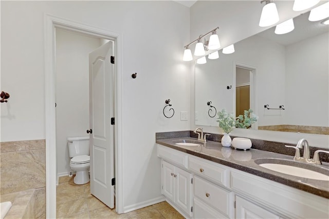 full bath with toilet, double vanity, tile patterned flooring, and baseboards