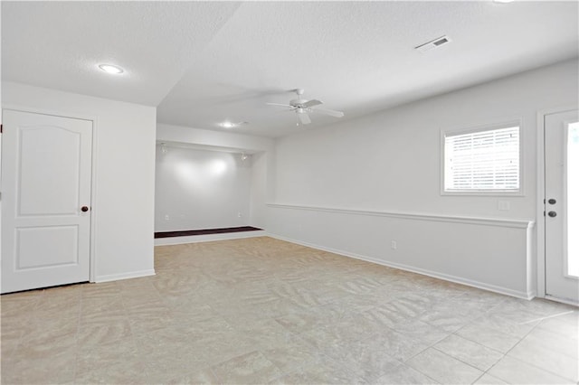 below grade area with a textured ceiling, a ceiling fan, recessed lighting, baseboards, and light flooring