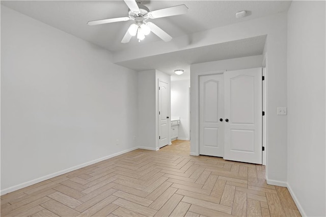 unfurnished bedroom featuring baseboards, connected bathroom, and ceiling fan